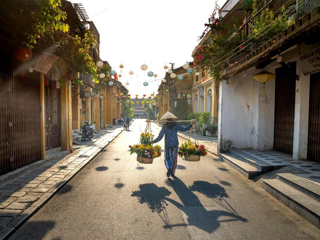 A Vietnamese Peddler Carrying Fruits On Shoulder