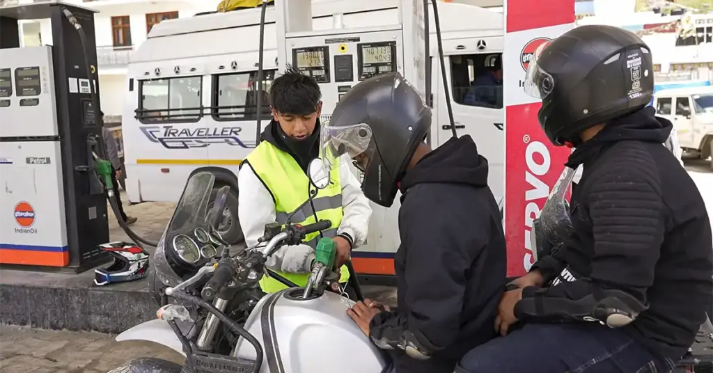 Rider refuelling at Indian Oil petrol pump in Kaza, Spiti Valley — the only fuel stop in the valley before Kunzum Pass and the Manali side