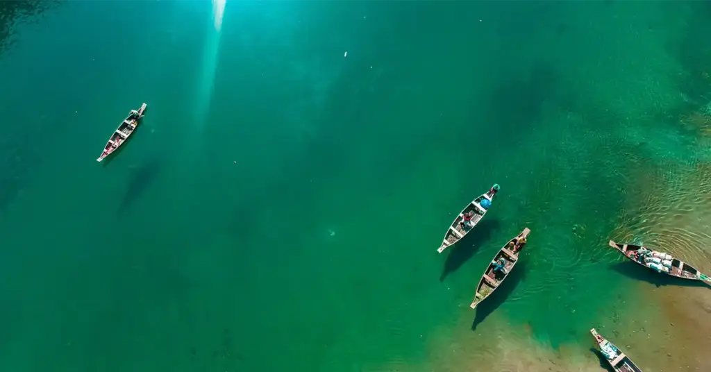 Aerial view of wooden boats floating on the crystalclear turquoise Umngot River in Dawki, Meghalaya