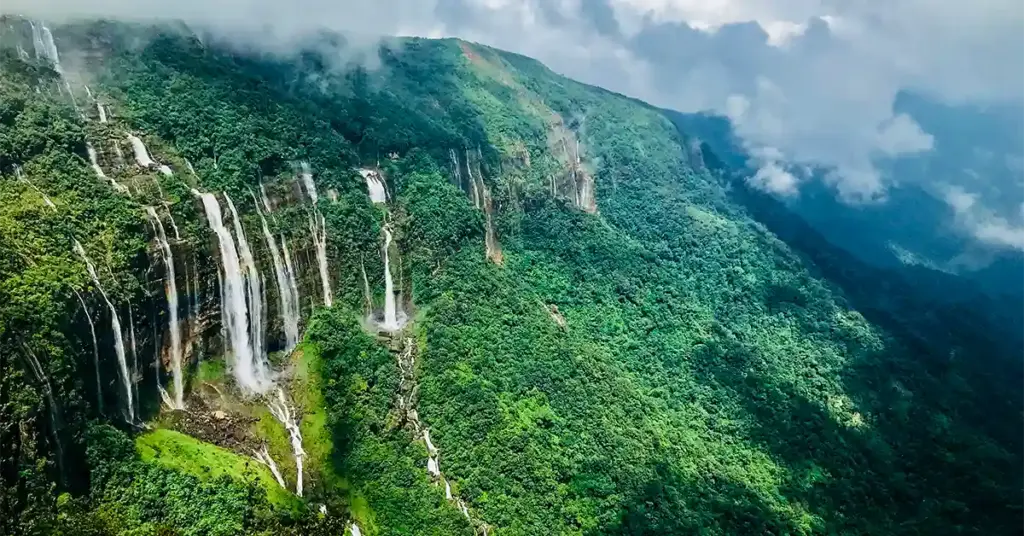 Aerial view of Seven Sisters Falls (Nohsngithiang Falls) cascading down a misty cliff near Cherrapunji, Meghalaya
